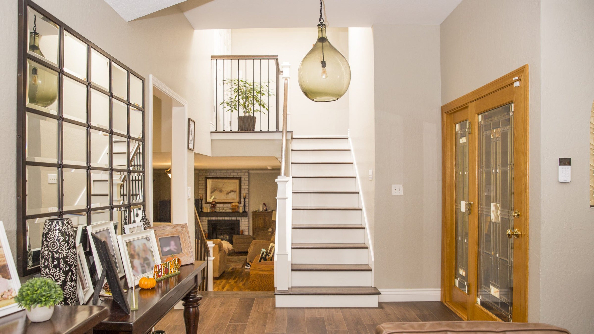 Staircase leading to an upper level in a home with a wooden floor and glass door.